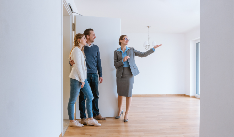 a couple being shown a property by a woman real estate agent
