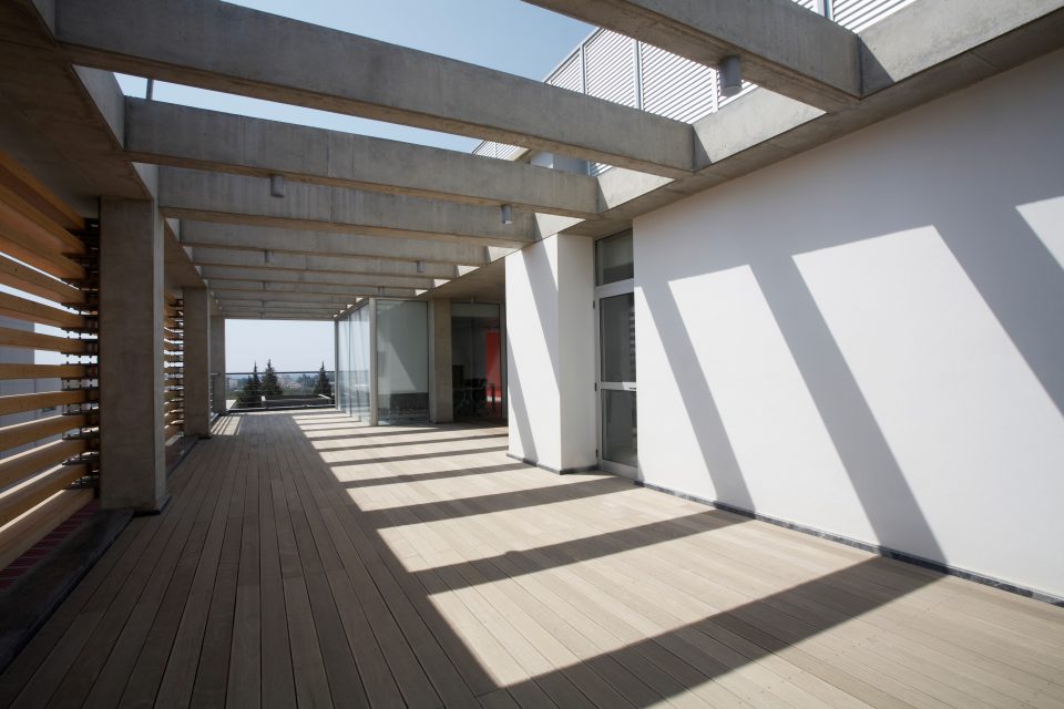 a composite deck on the exterior of a property underneath a wood deck veranda