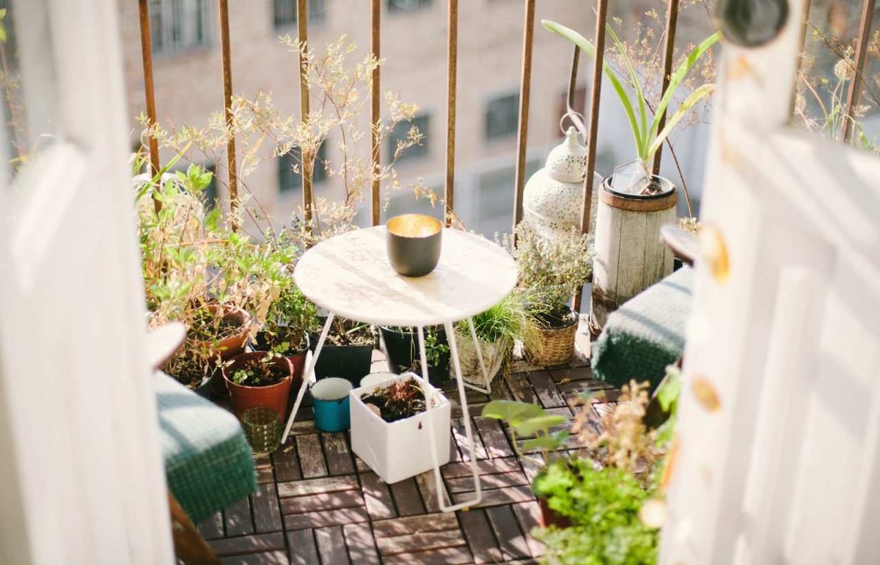 a garden with table and chairs built on a small balcony