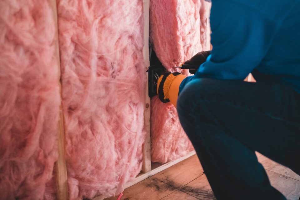 a person installing insulation in a renovated attic