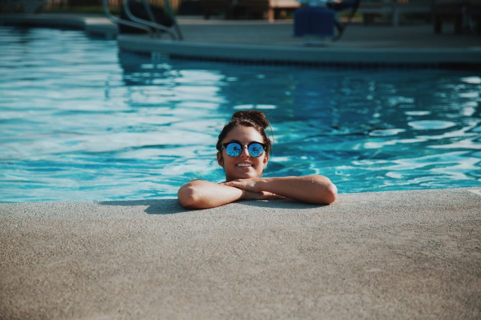 a woman swimming in an inground pool