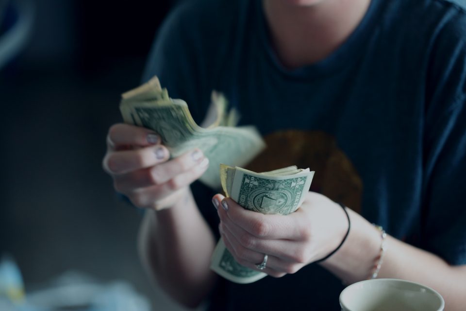 a person counting cash in their hands