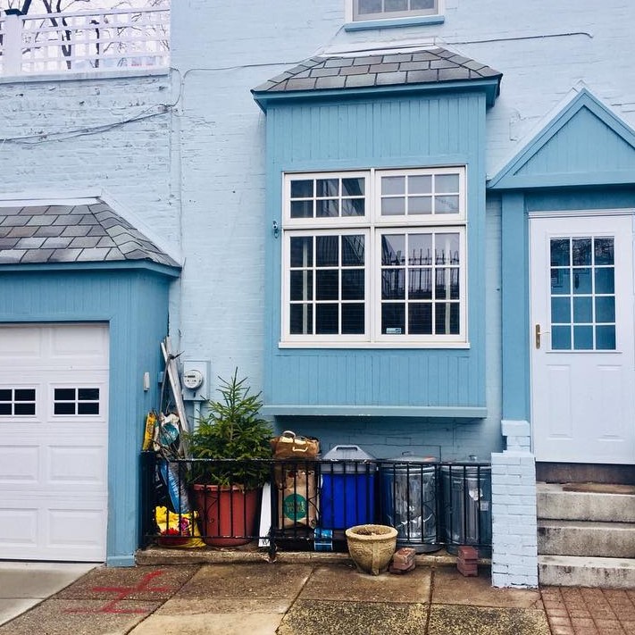 a front of house painted blue with a white door