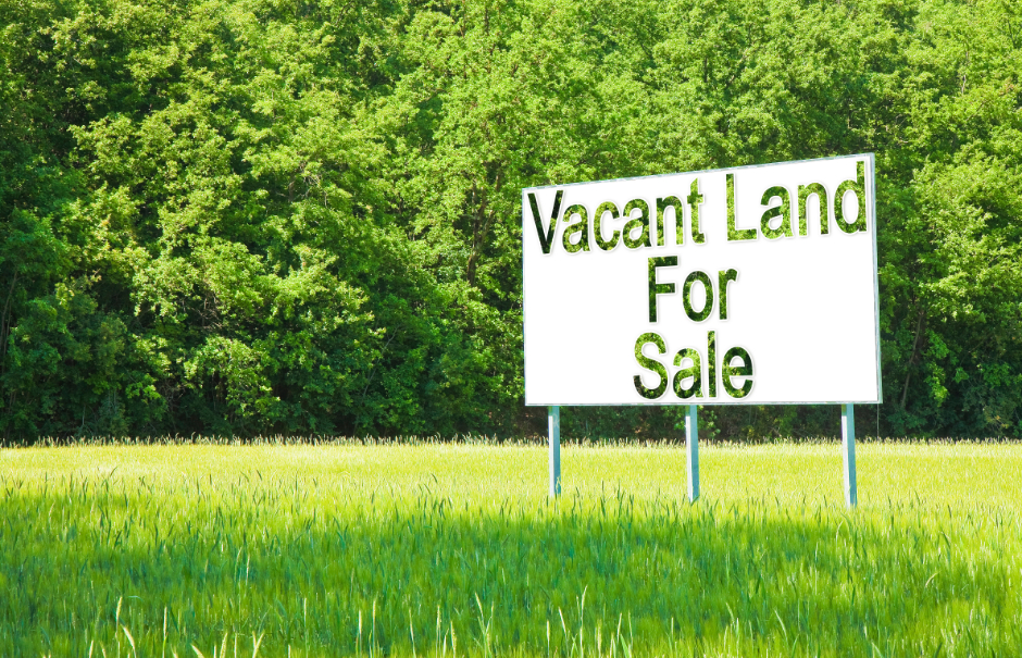 a vacant land for sale board in a field