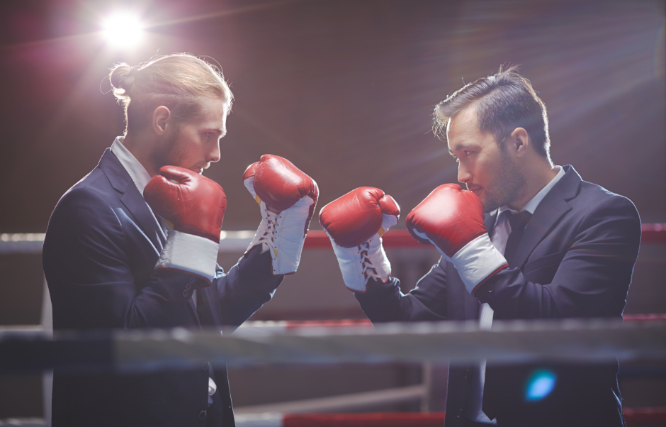 two men in suits confronting each other wearing boxing gloves