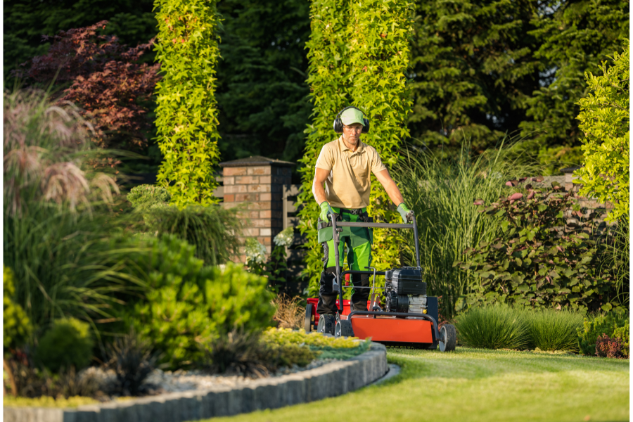 a man mowing a large lawn with a lawnmower