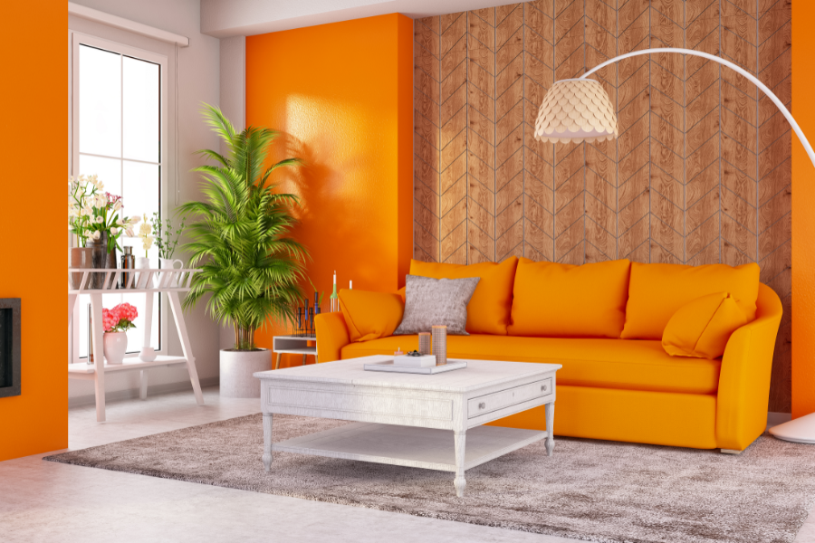 an airbnb living room with orange walls and orange couch