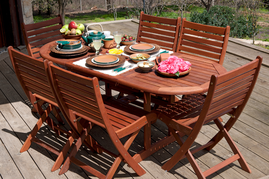 a set wooden outdoor dining table in a backyard