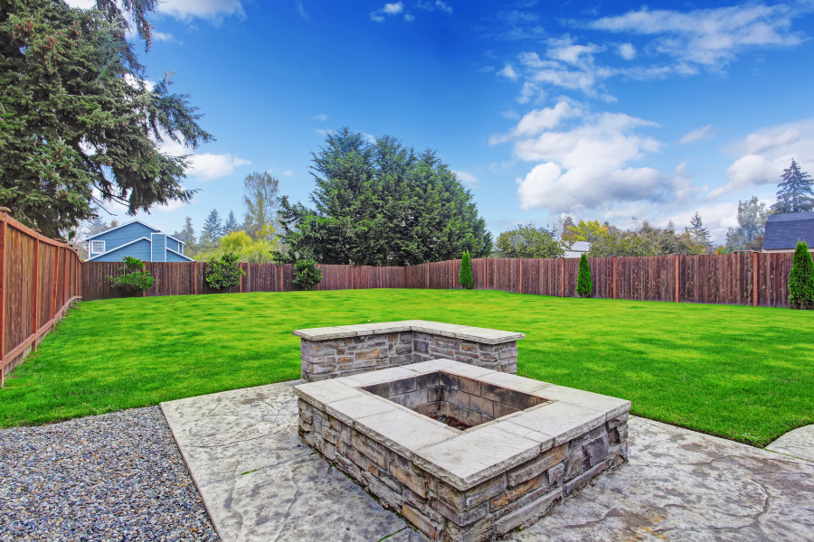 a large backyard with a built in firepit on the patio