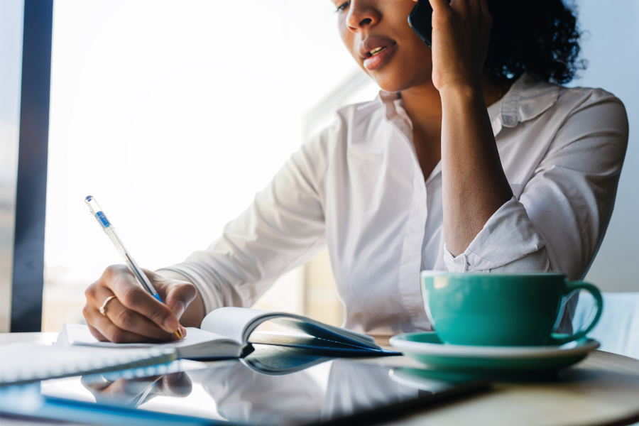 a woman speaking on the telephone filling in paperwork