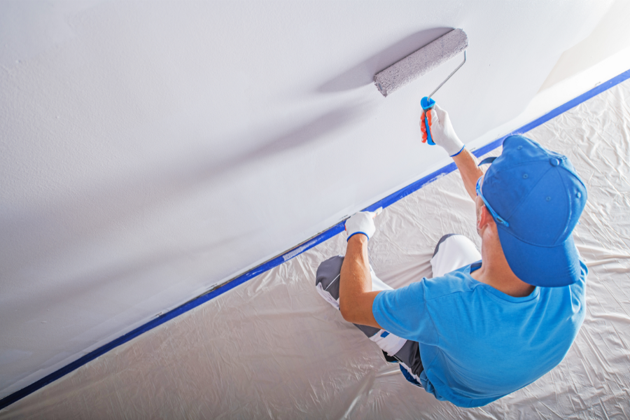 a man painting walls in a room