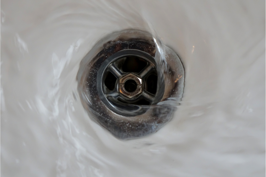 water spiralling down a drain at home