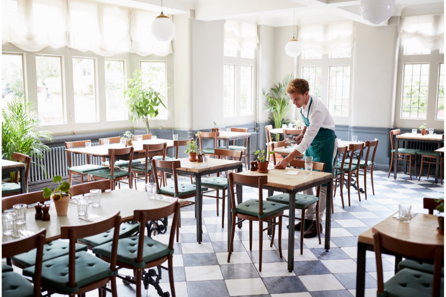 a waitress cleaning tables in a restaurant