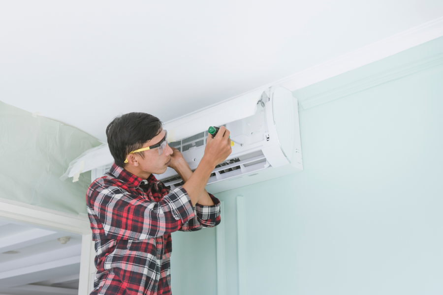 a man in a property fixing an air conditioning unit