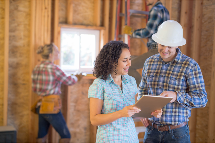 a man and woman contractor on a building site discussing a project