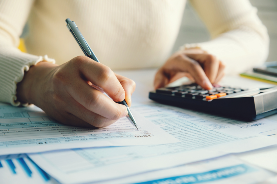 a person filing property taxes using a calculator