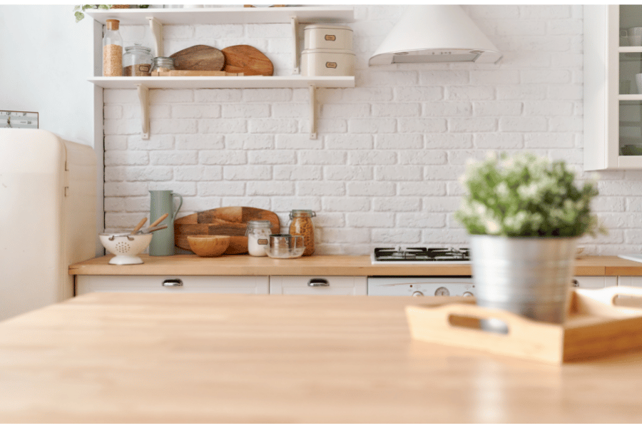 a small kitchen with a wooden countertop and white tiles