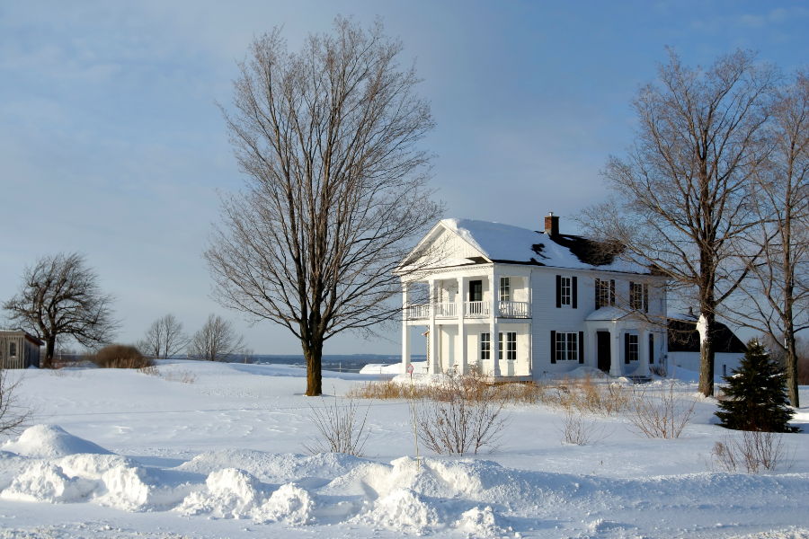 a large remote property with snow on the house and driveway