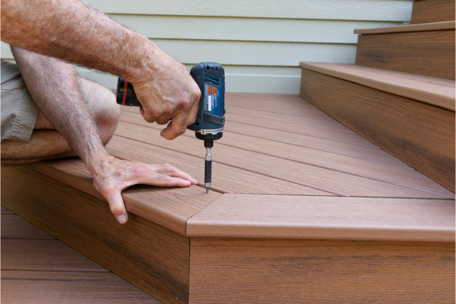 a person installing and drilling into a composite deck