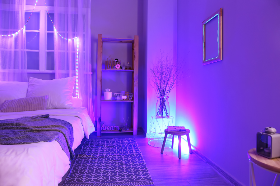 a bedroom with neon lights hanging over the bed and in a corner lamp