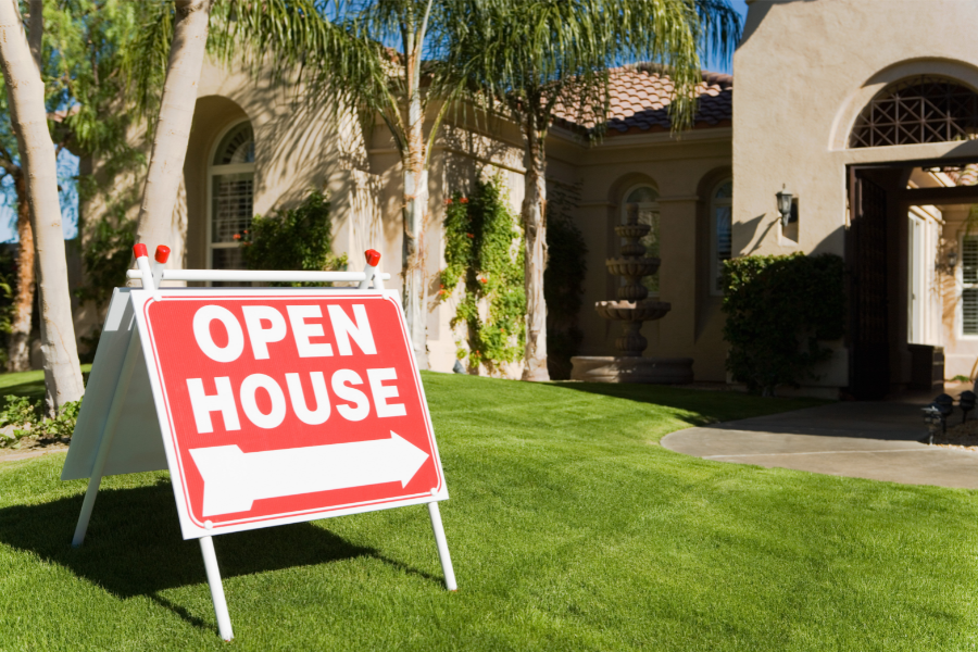 a property with an open house sign on the front lawn